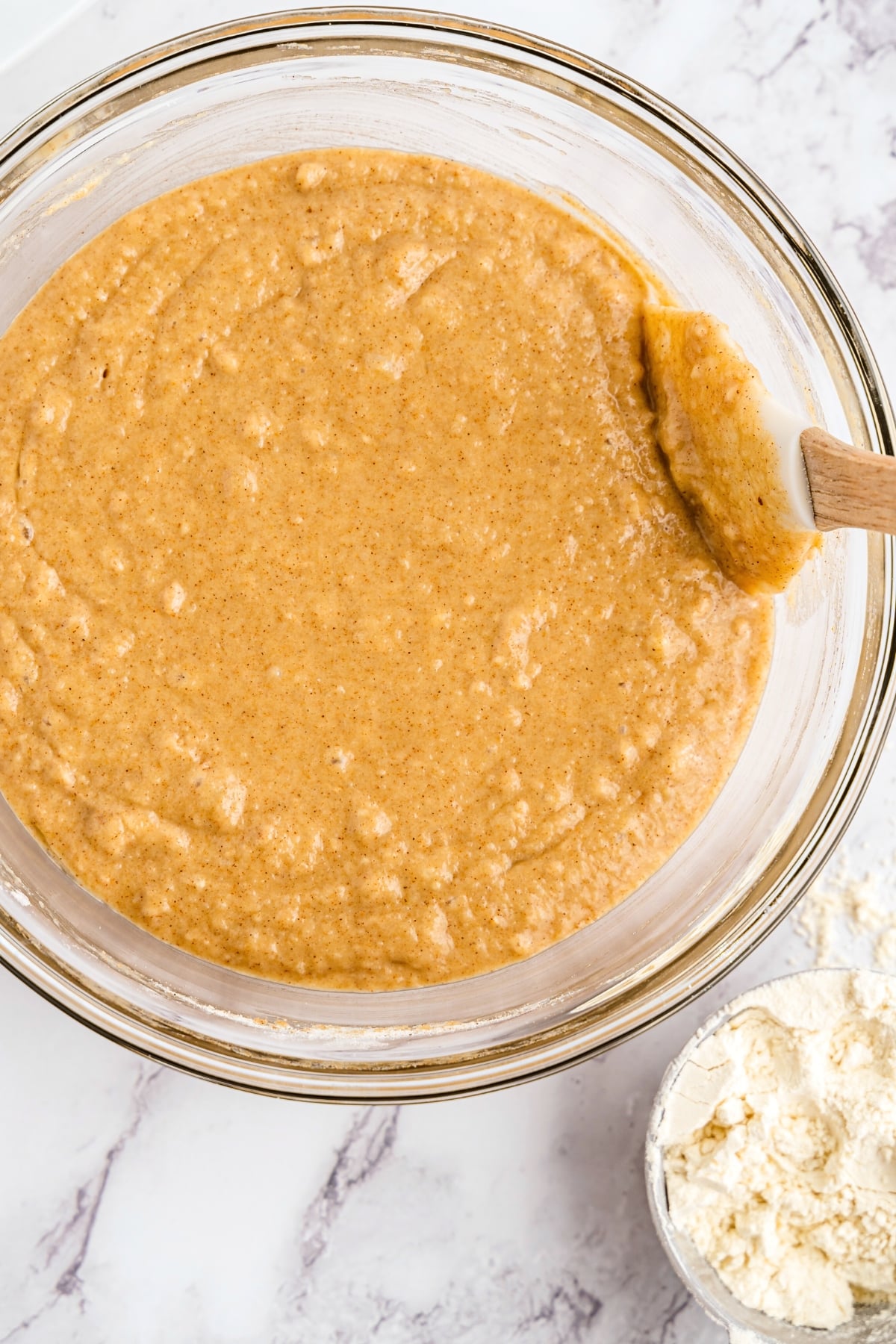 Mixing muffin batter in glass bowl.