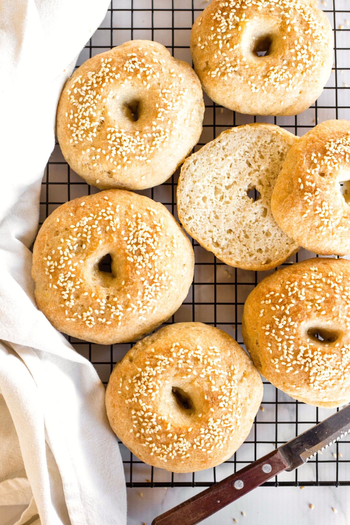 Top down view of gluten-free bagels cooling on wire rack.