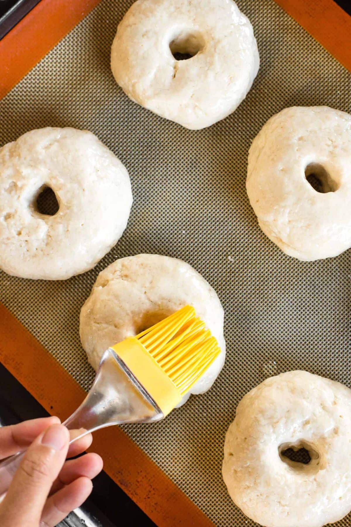 Brushing bagel dough with oil.