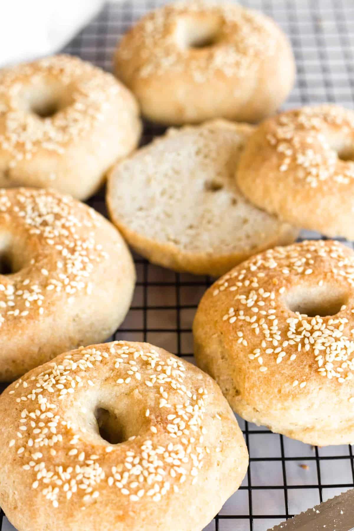 Half-sliced gf bagels on wire rack.