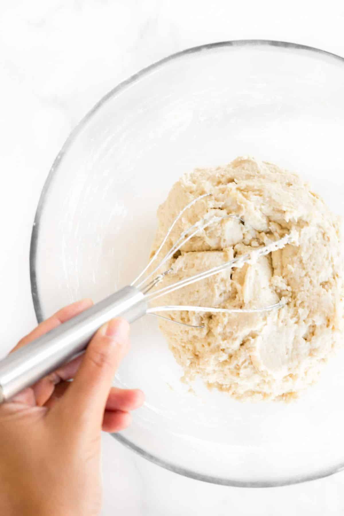 Mixing bagel dough in glass bowl.