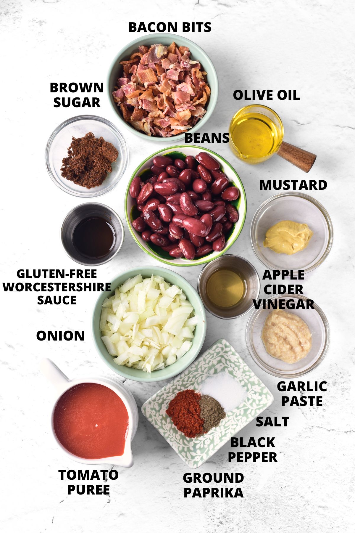 Top down view of ingredients for gluten-free baked beans laid out on marble board.