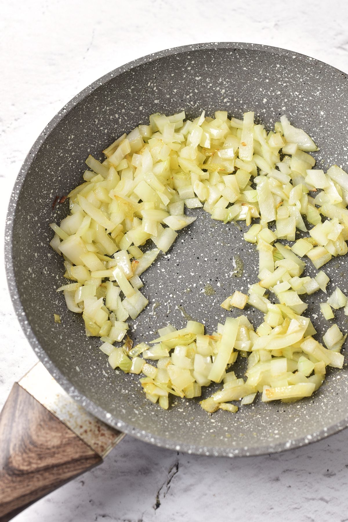 Sautéing diced onions in skillet.