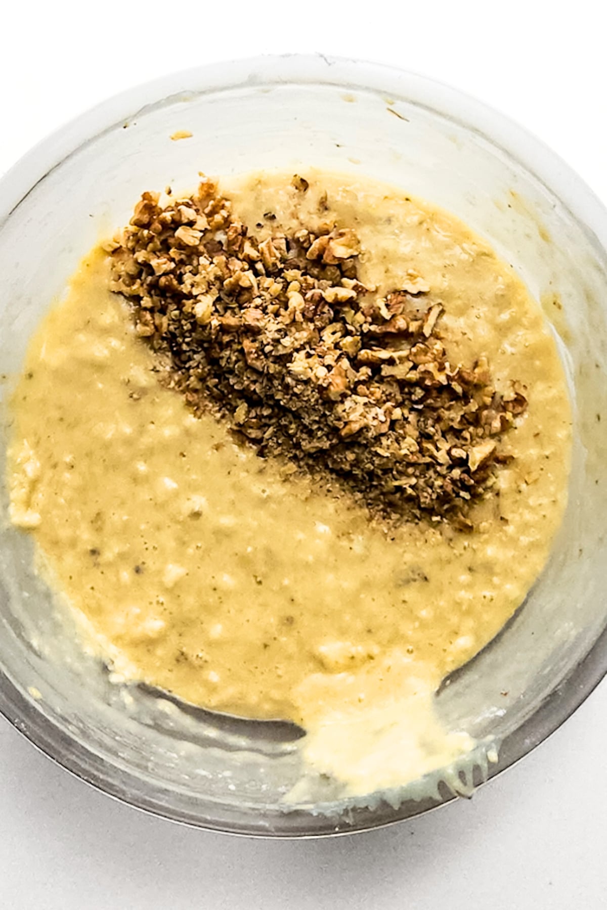 Chopped walnuts on top of pale yellow batter.