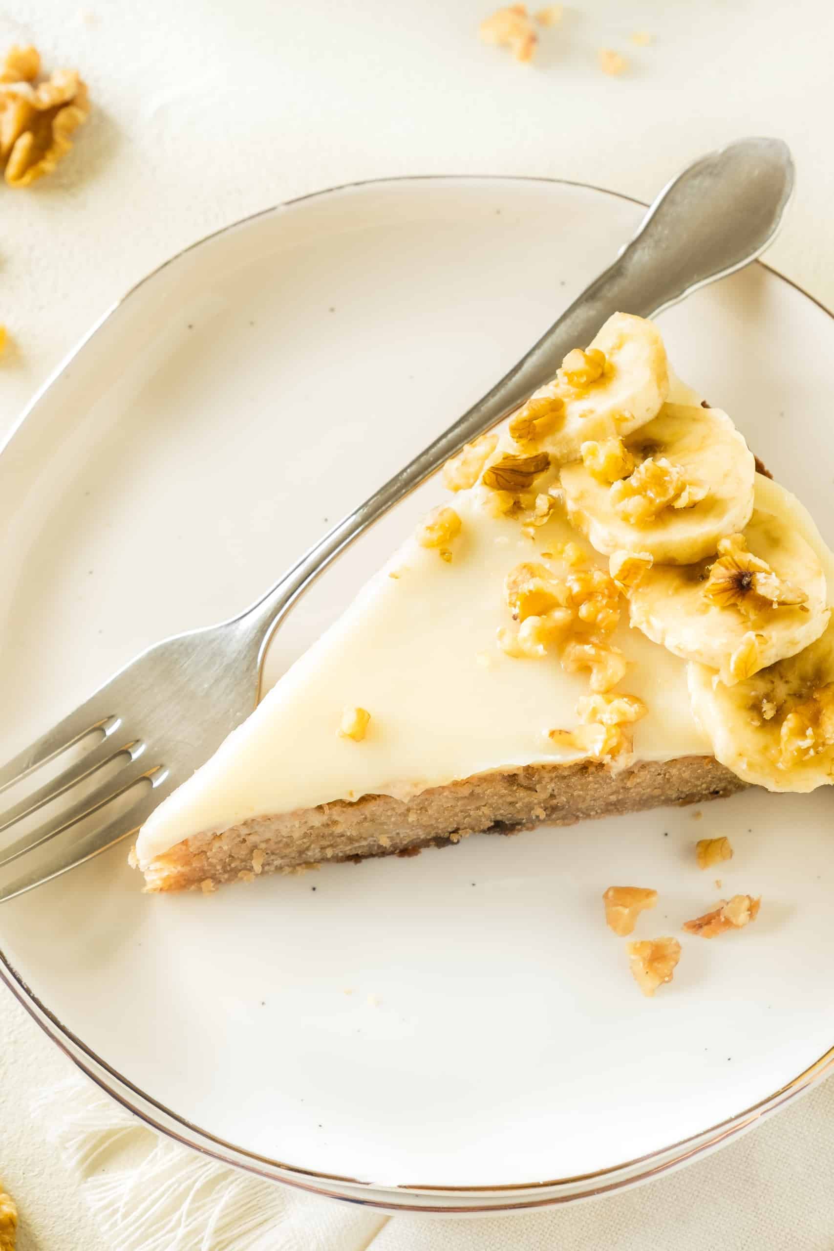 A slice of gluten-free banana cake on a white round plate.