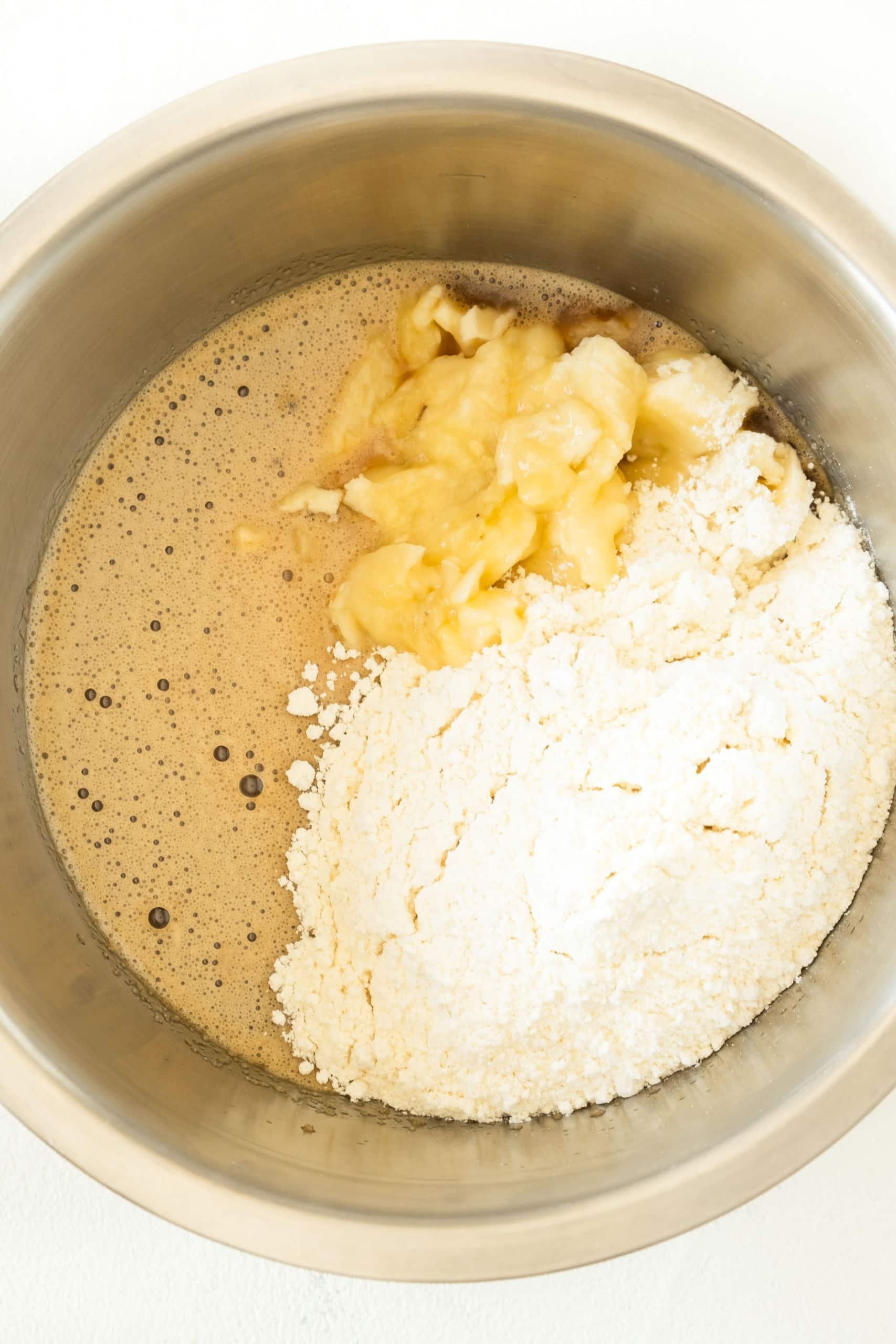 Ingredients for banana cake batter in a metal bowl.