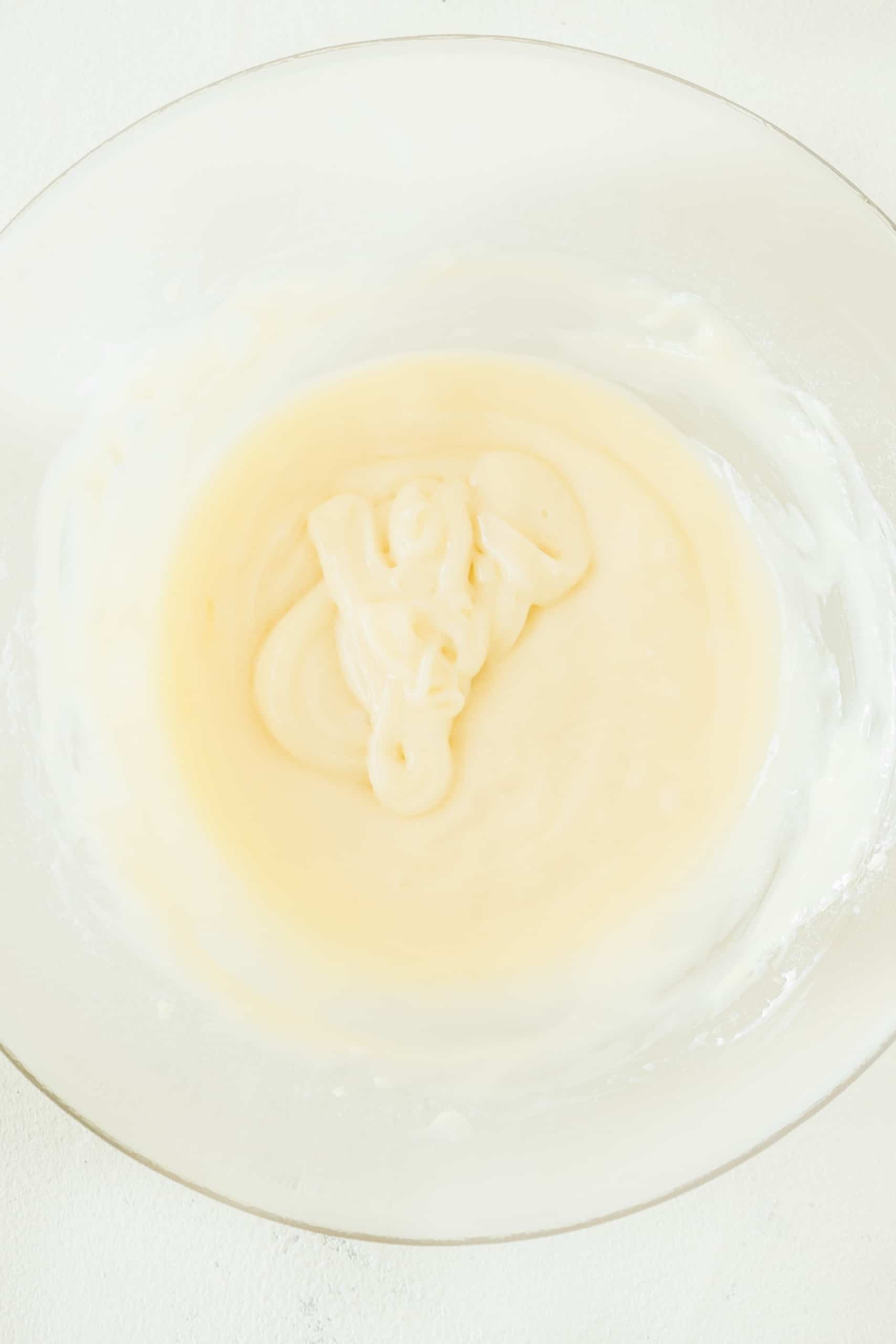 Cream cheese frosting in glass bowl.