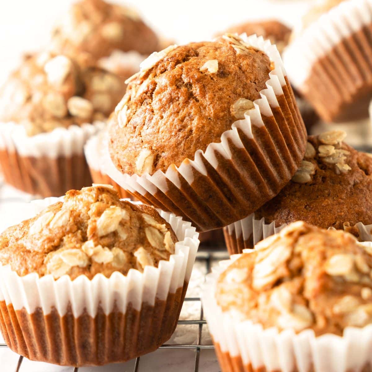 Gluten-free banana oatmeal muffins stacked on wire rack