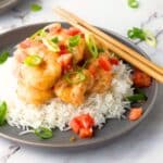 A plate of bang bang shrimp served over rice.
