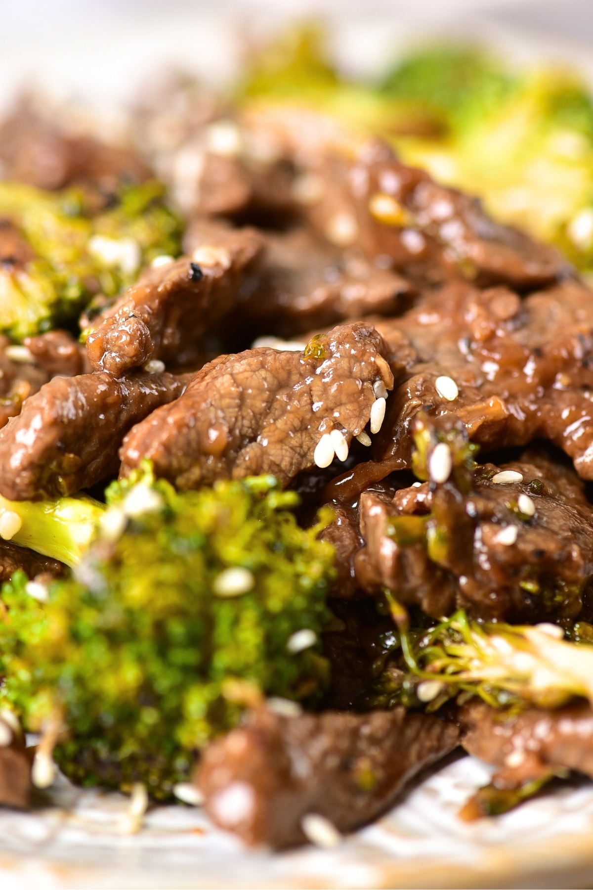 Up close shot of gluten-free beef stir fry with broccoli and sesame seeds.