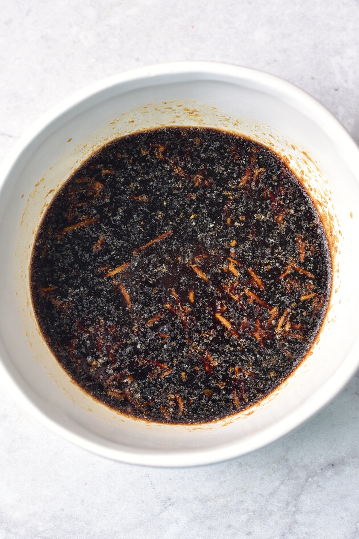 Mixing black sauce ingredients in white bowl.