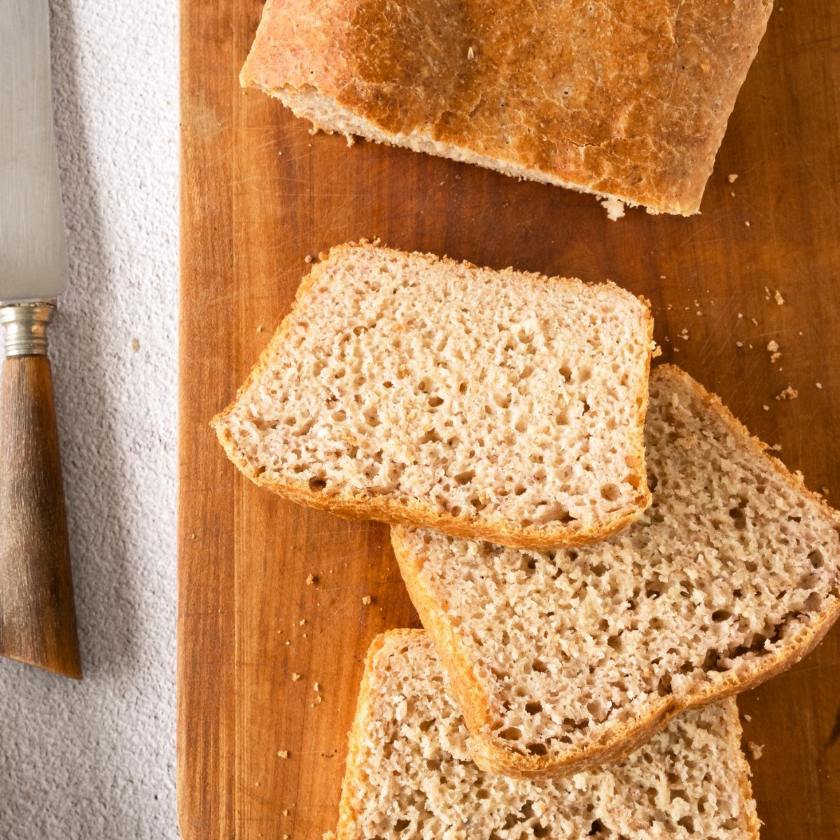 Slices of gf beer bread on wooden board.