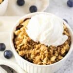Gluten-free blueberry crisp topped with vanilla ice cream.