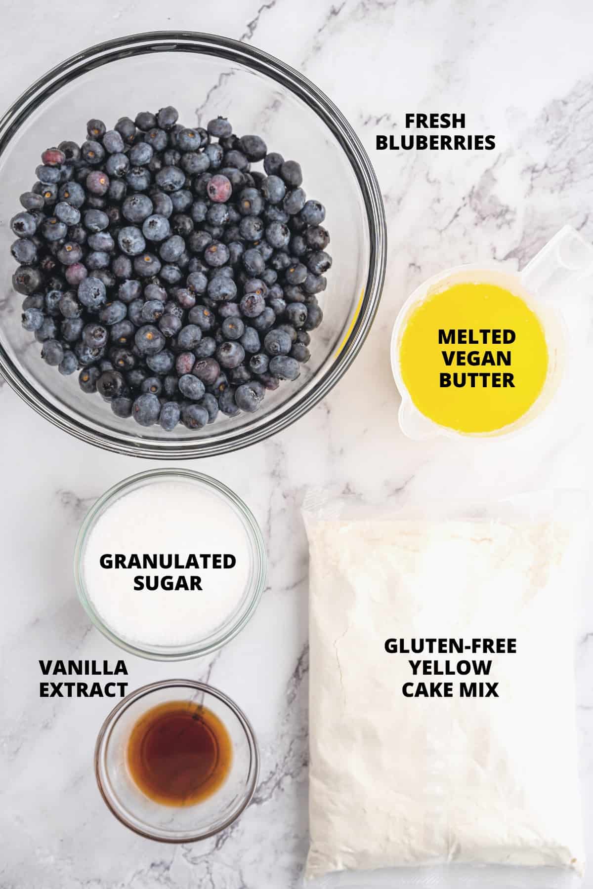 Ingredients for gluten-free dump cake recipe laid out on marble board.