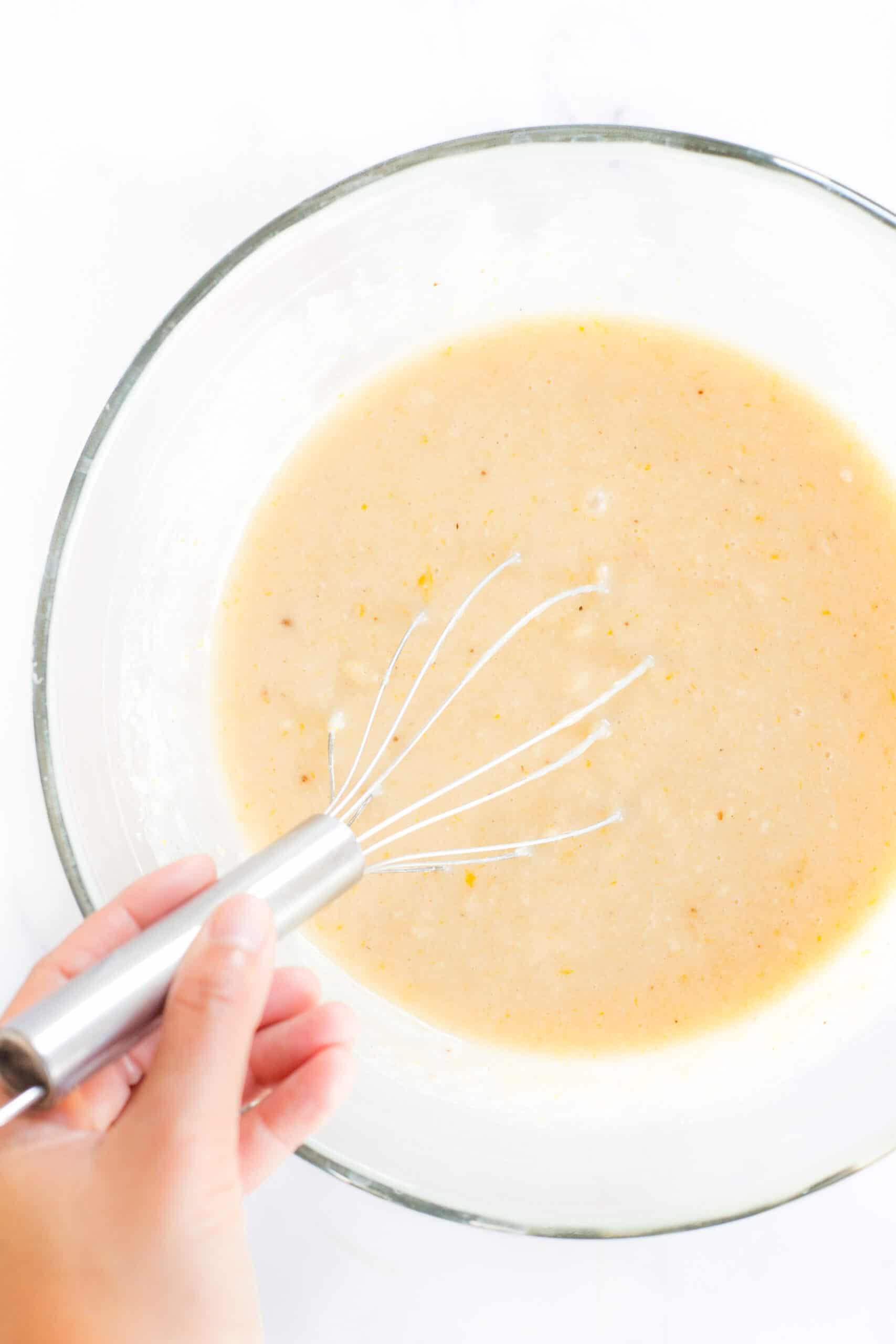 Whisking batter in a glass bowl.