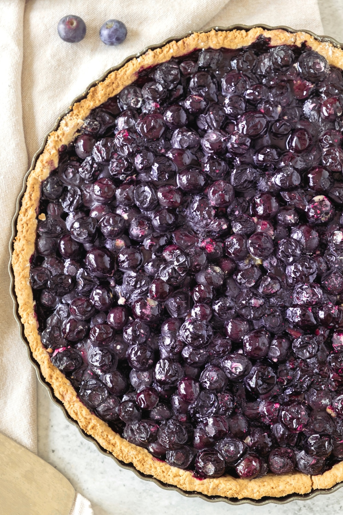 Up close shot of freshly baked blueberry pie on kitchen towel.