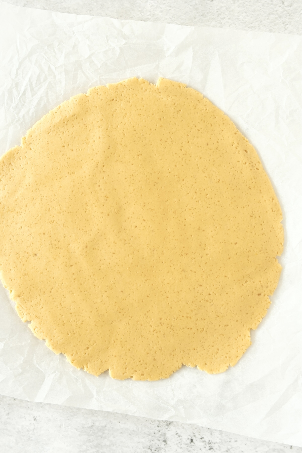 Rolled pie dough on parchment paper.