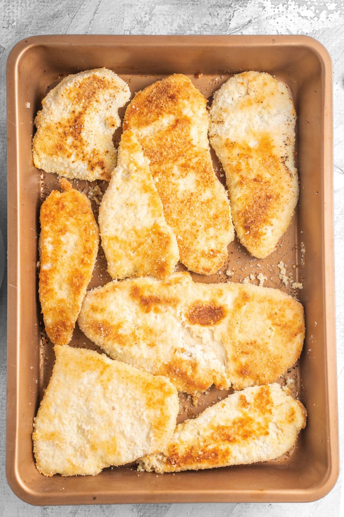 A baking sheet with freshly baked gluten-free breaded chicken