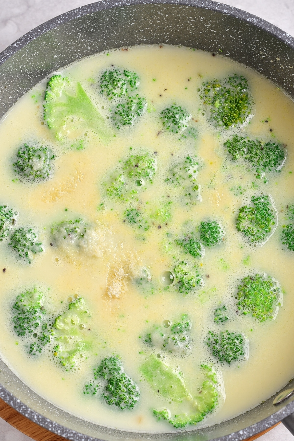 Cooking fresh broccoli florets in soup.
