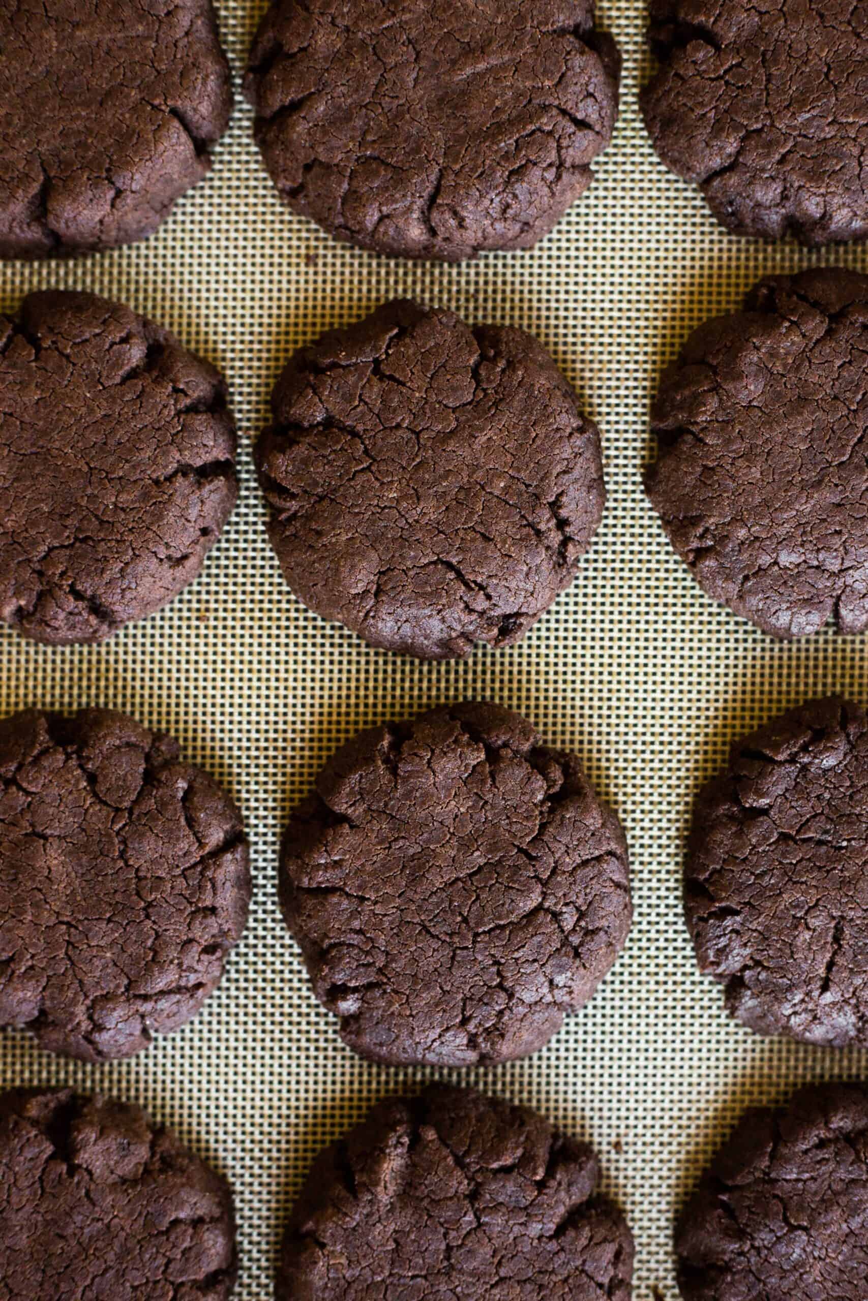Freshly baked gluten-free brownie cookies on a silpat.