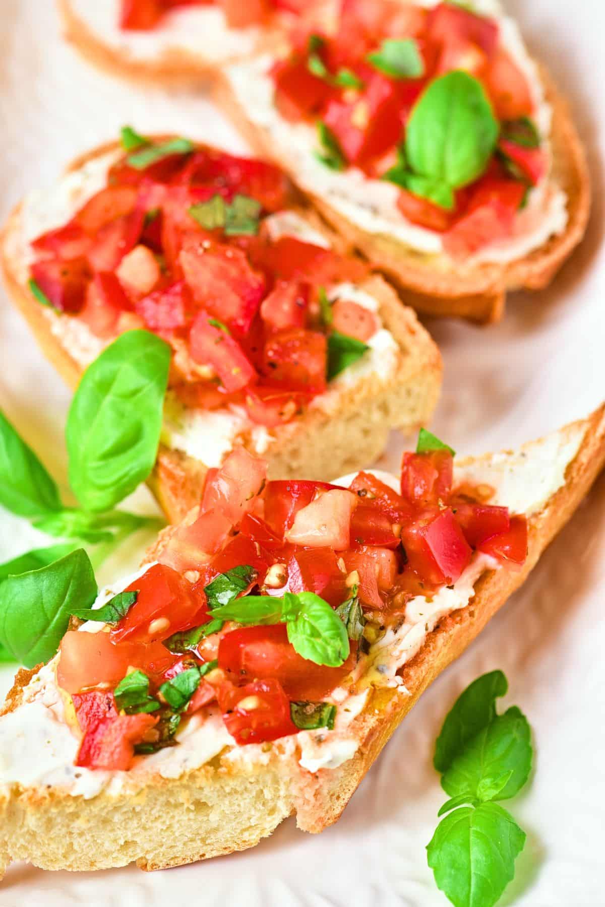 Up close view of gluten-free bruschetta garnished with basil leaves.