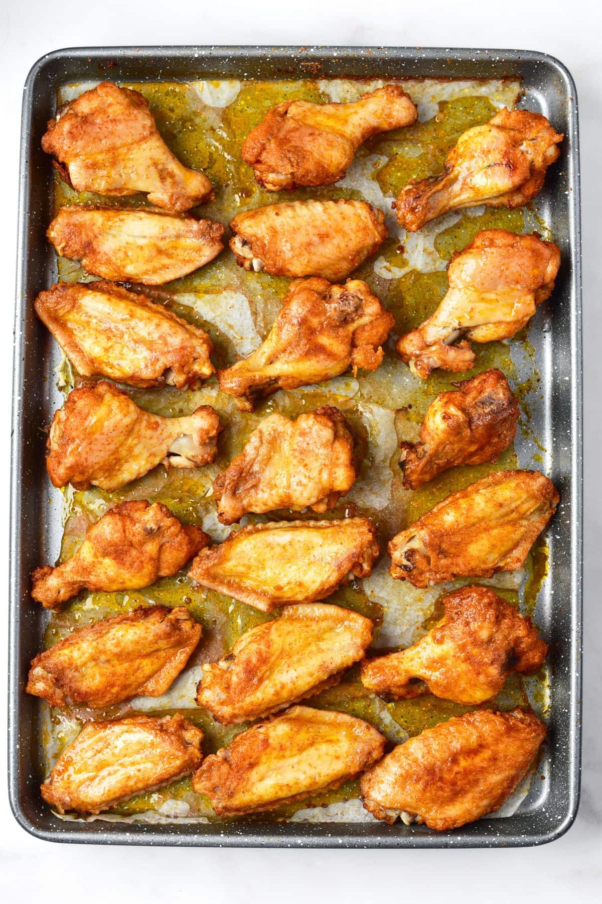 Baked chicken wings on baking sheet