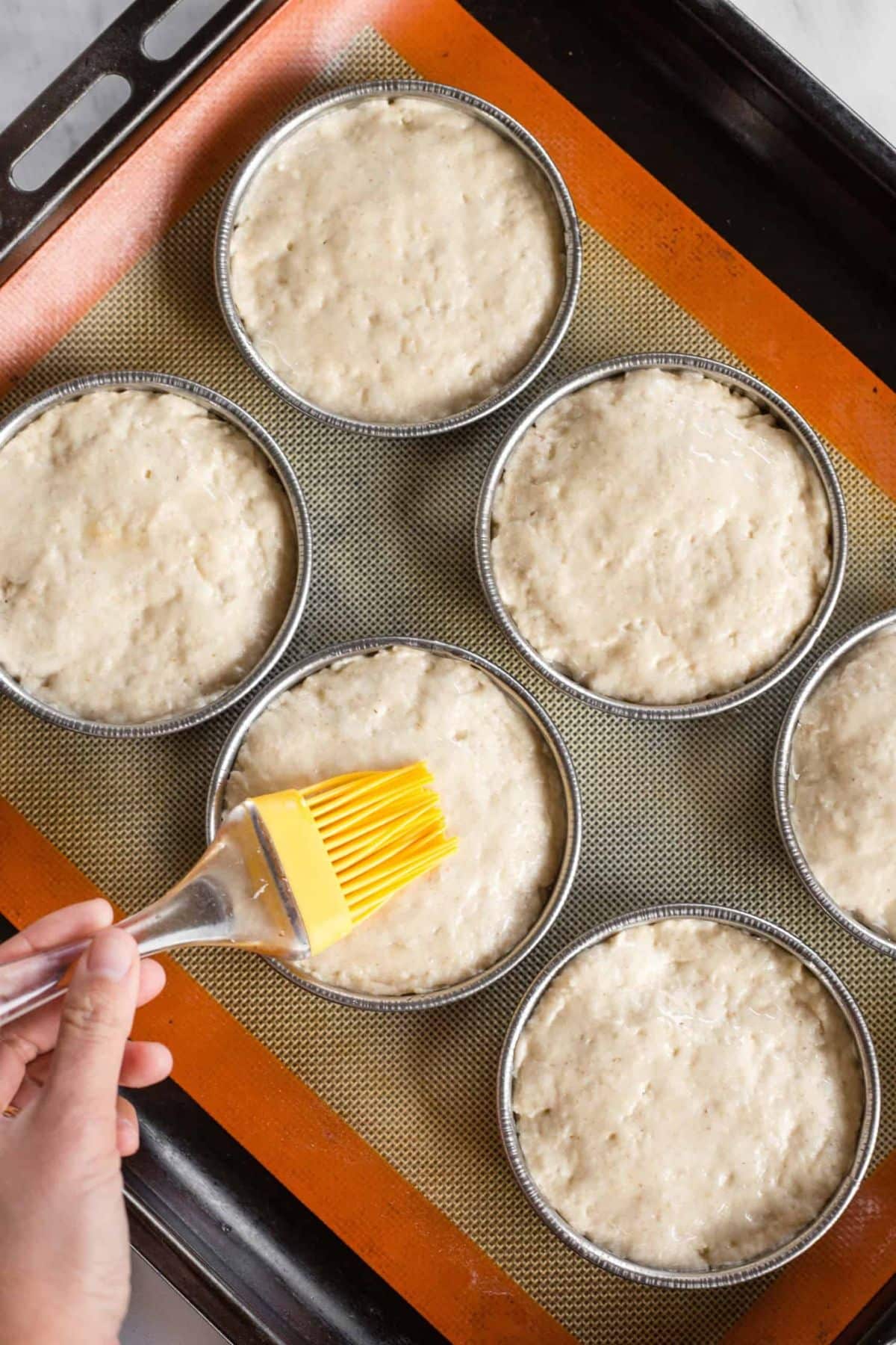 Brushing dough with oil.