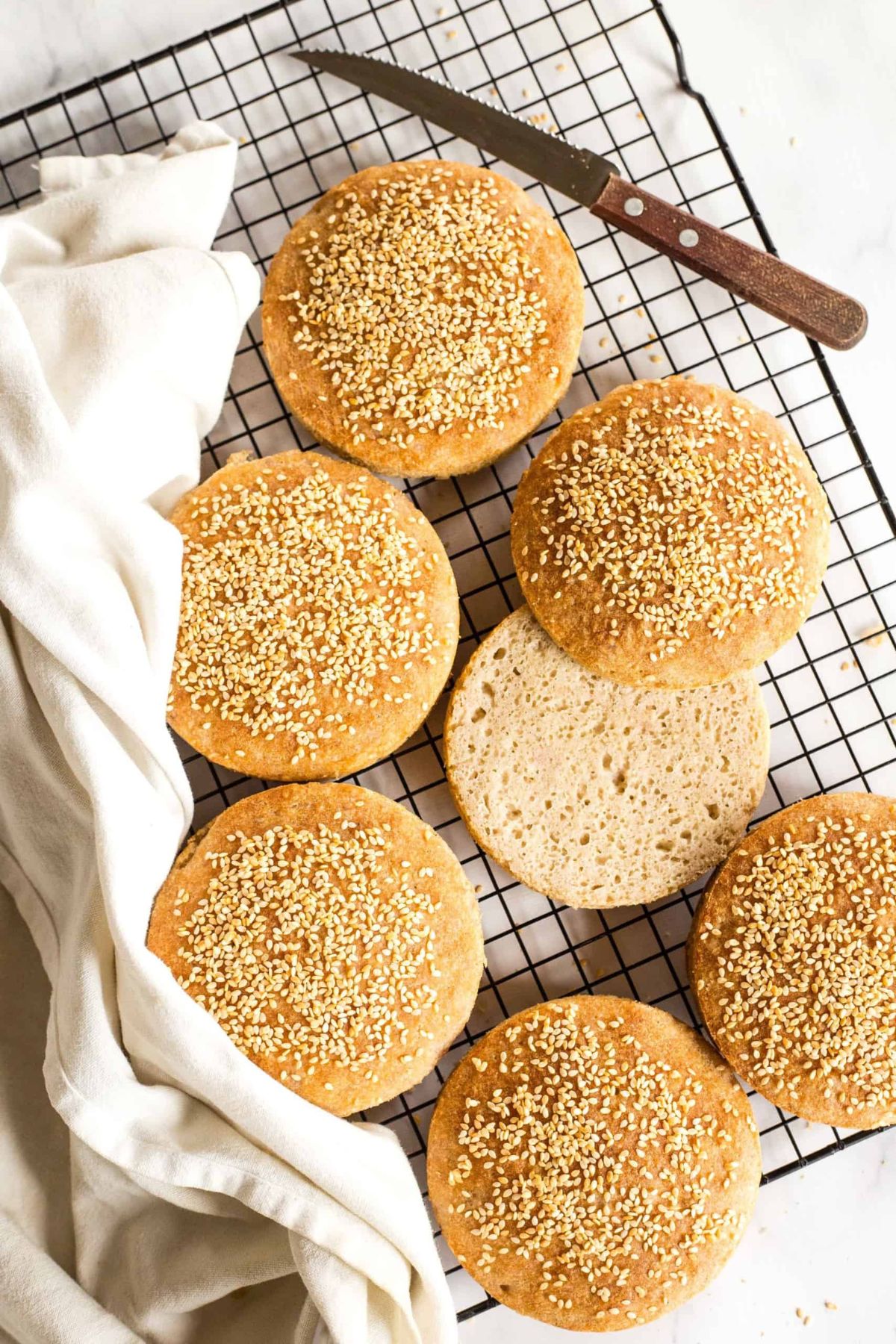 Top down view of gluten-free burger buns on wire rack.