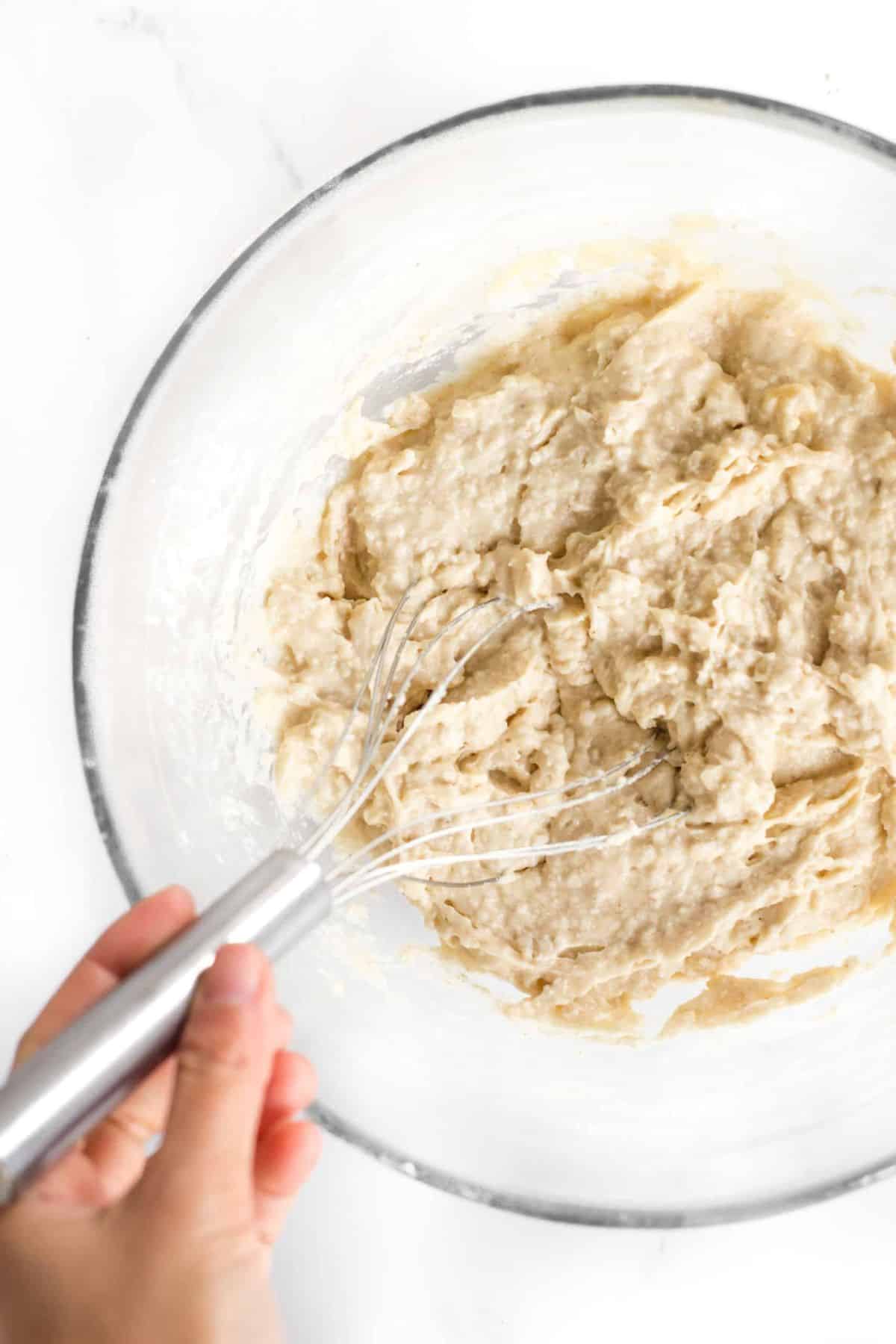 Mixing gluten-free hamburger bun dough in glass bowl.