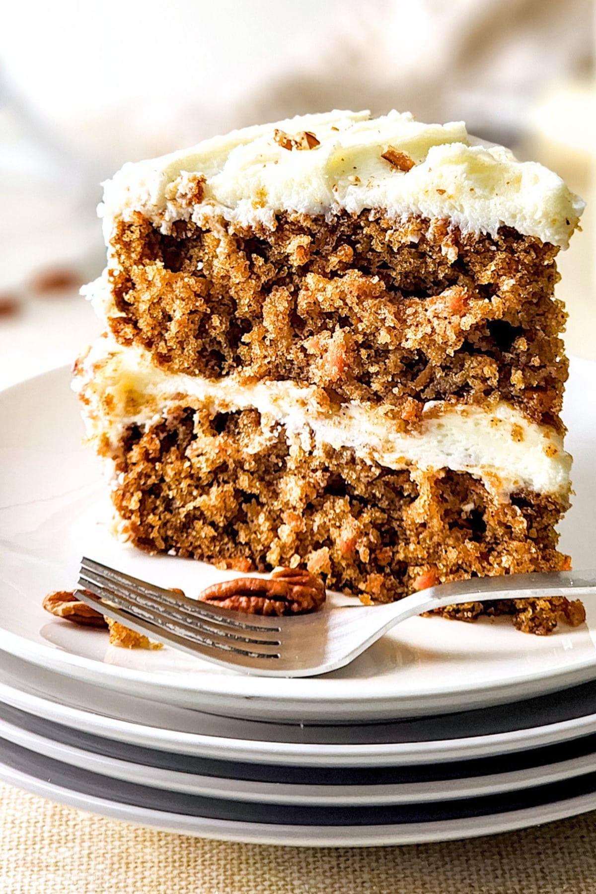 A big slice of gf carrot cake on white plate.