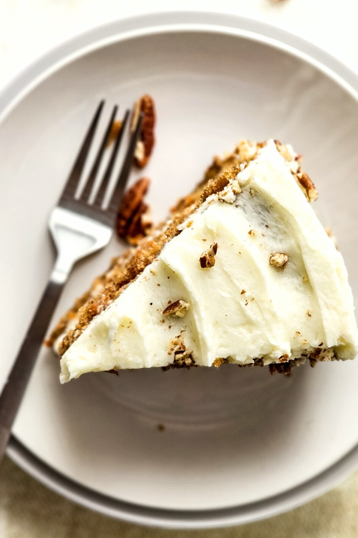 Top down view of a slice of carrot cake with cream cheese frosting.