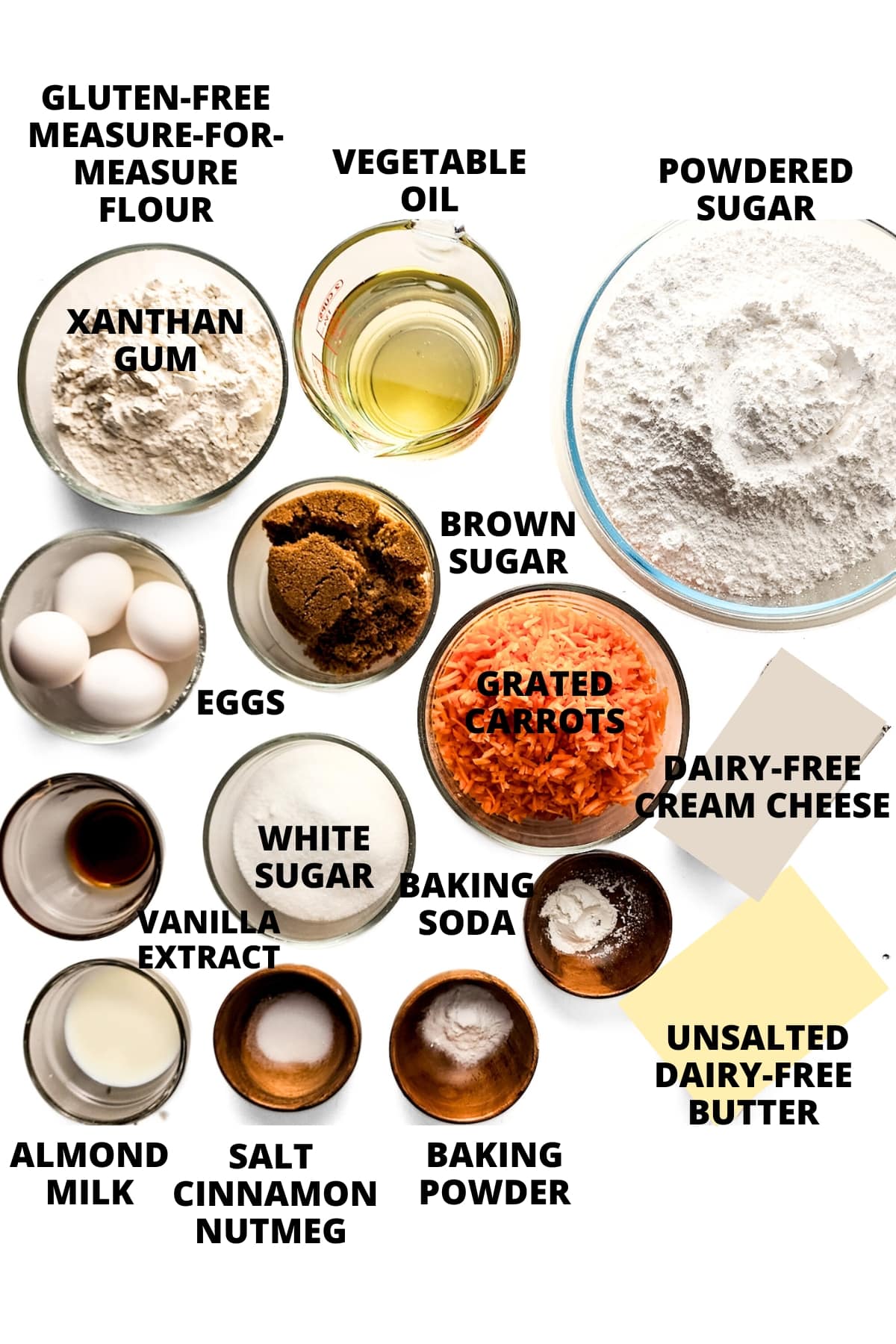 Ingredients for gluten-free carrot cake recipe laid out on white board.