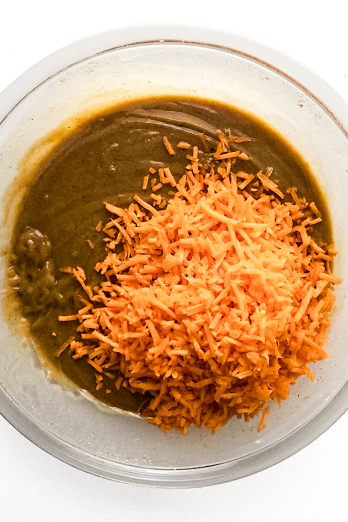 Shredded carrots on top of brown liquid mixture.
