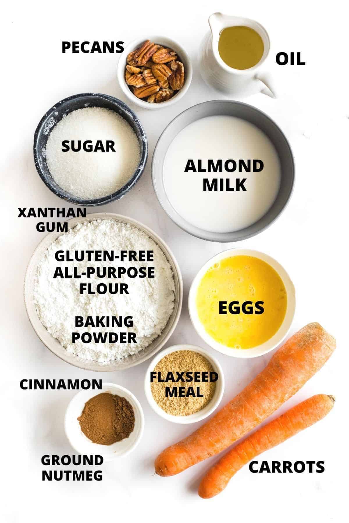 Ingredients for gluten-free carrot muffins laid out on marble board.