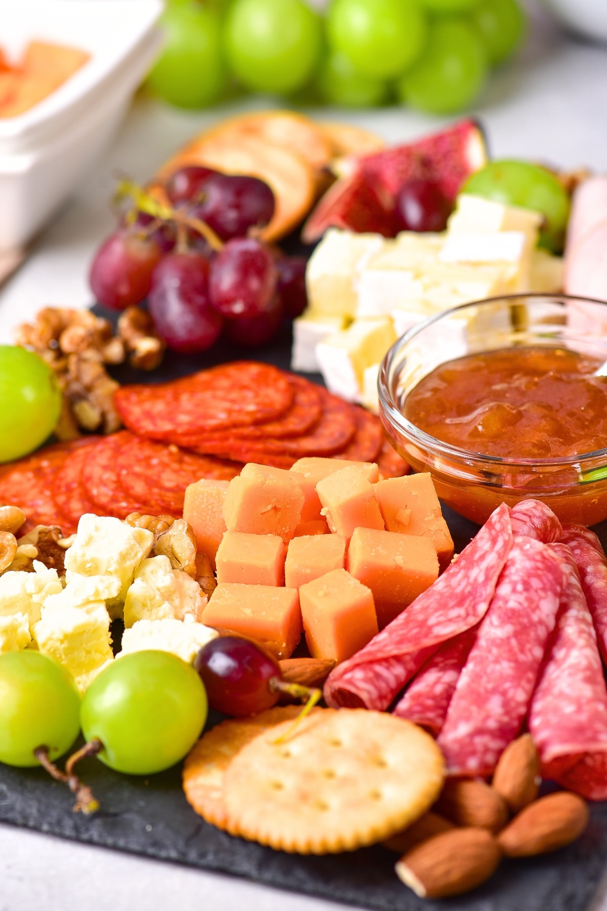 Up close view of cheeses and meats on serving platter.