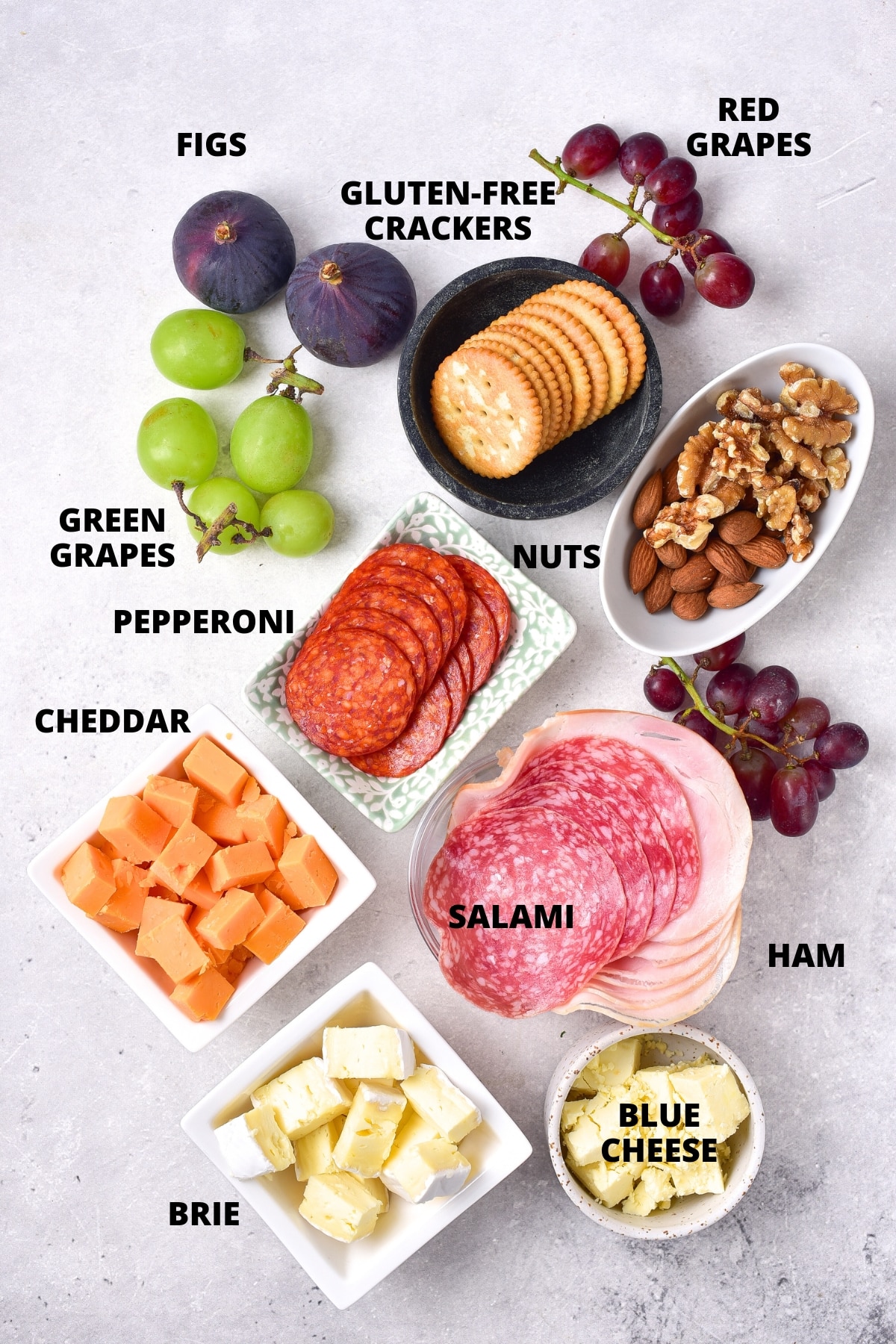 Ingredients for charcuterie board laid out on board.