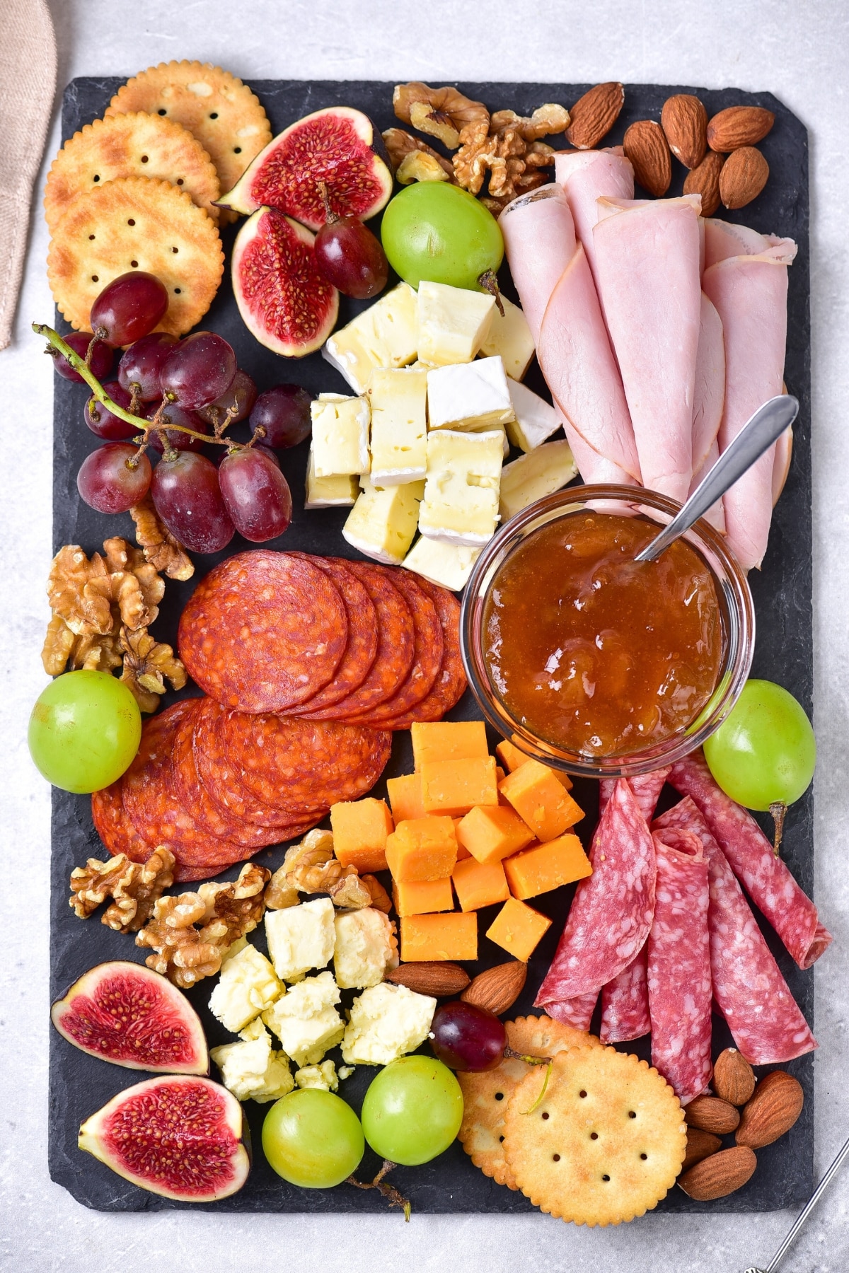 Top down view of charcuterie board on stone slate.