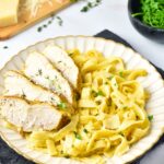A plate of gluten-free chicken alfredo on kitchen towel.
