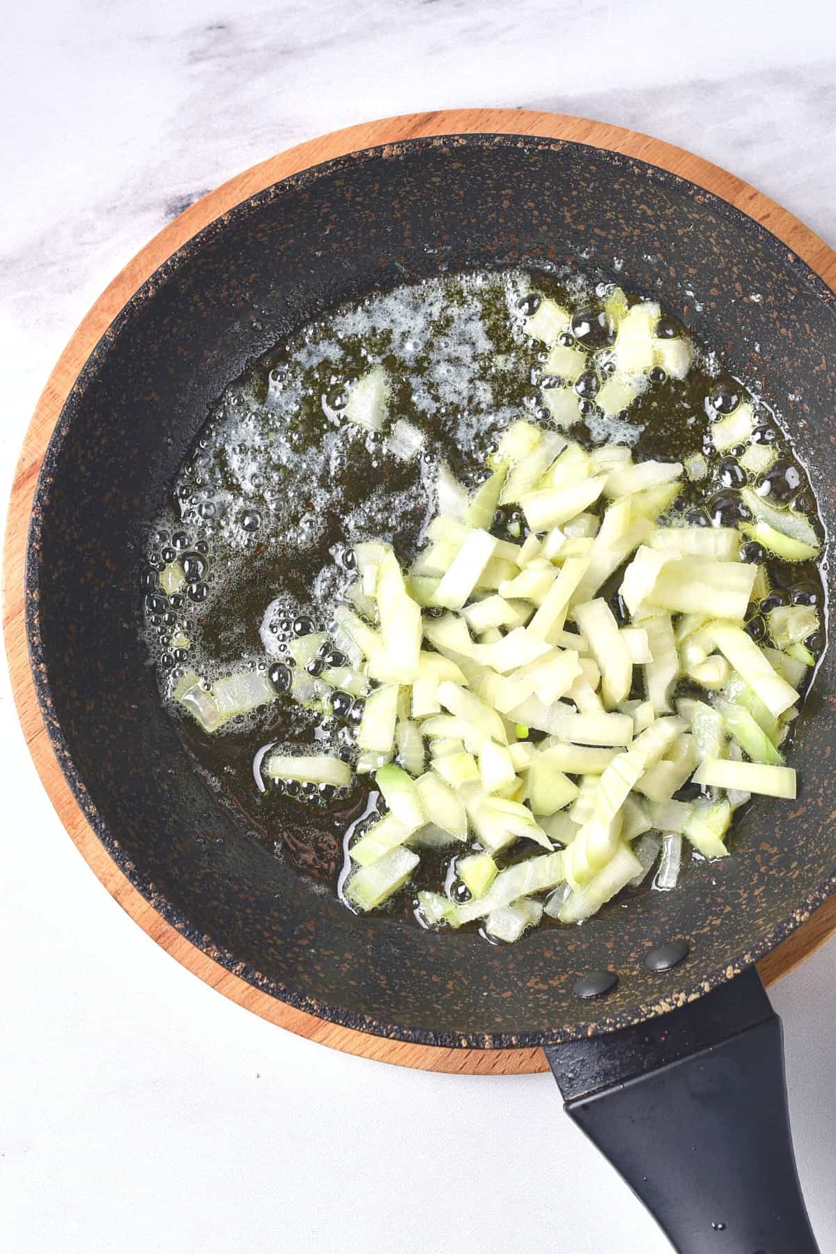 Sautéing diced onions in a skillet.