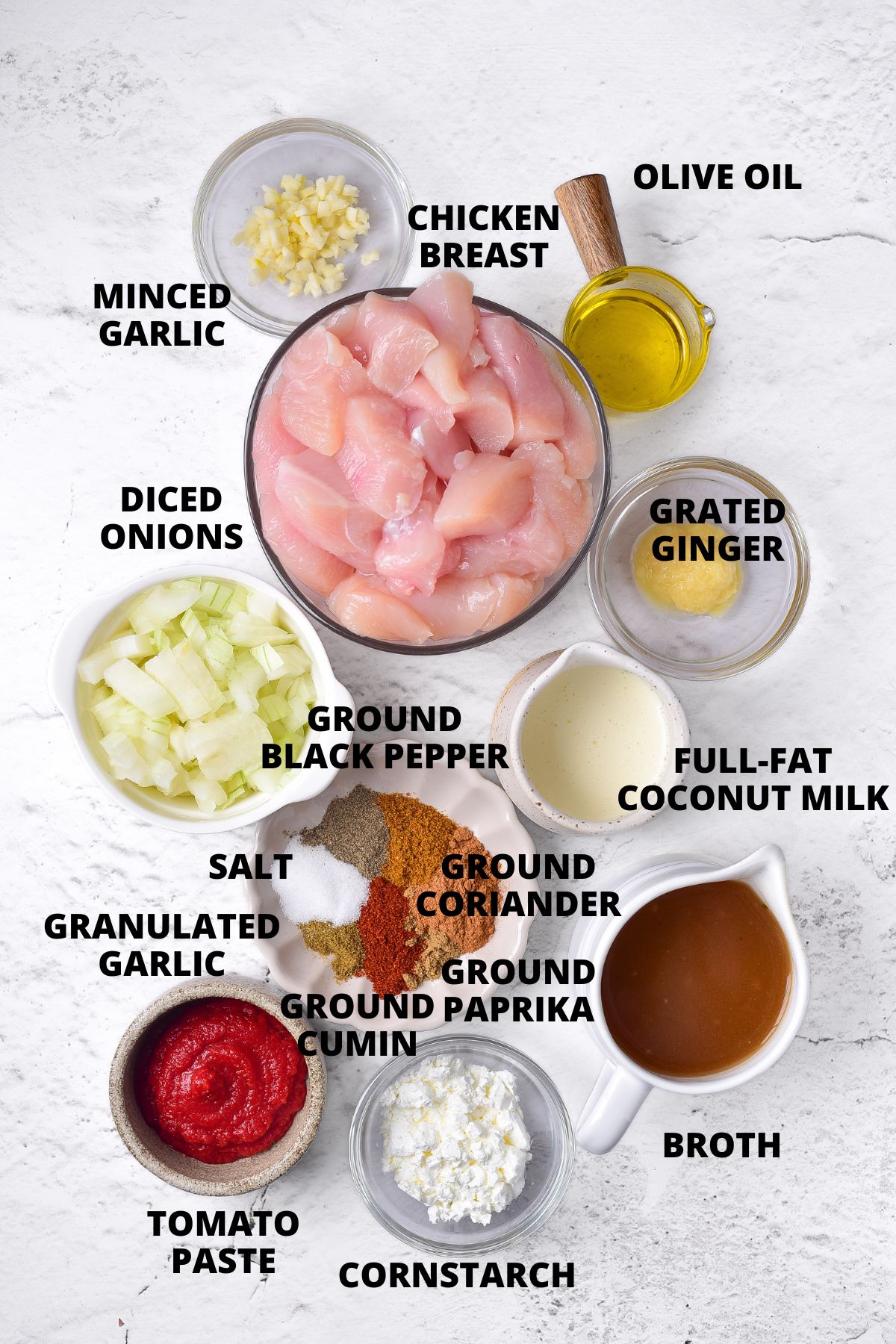 Ingredients for gluten-free chicken curry recipe laid out on marble board.