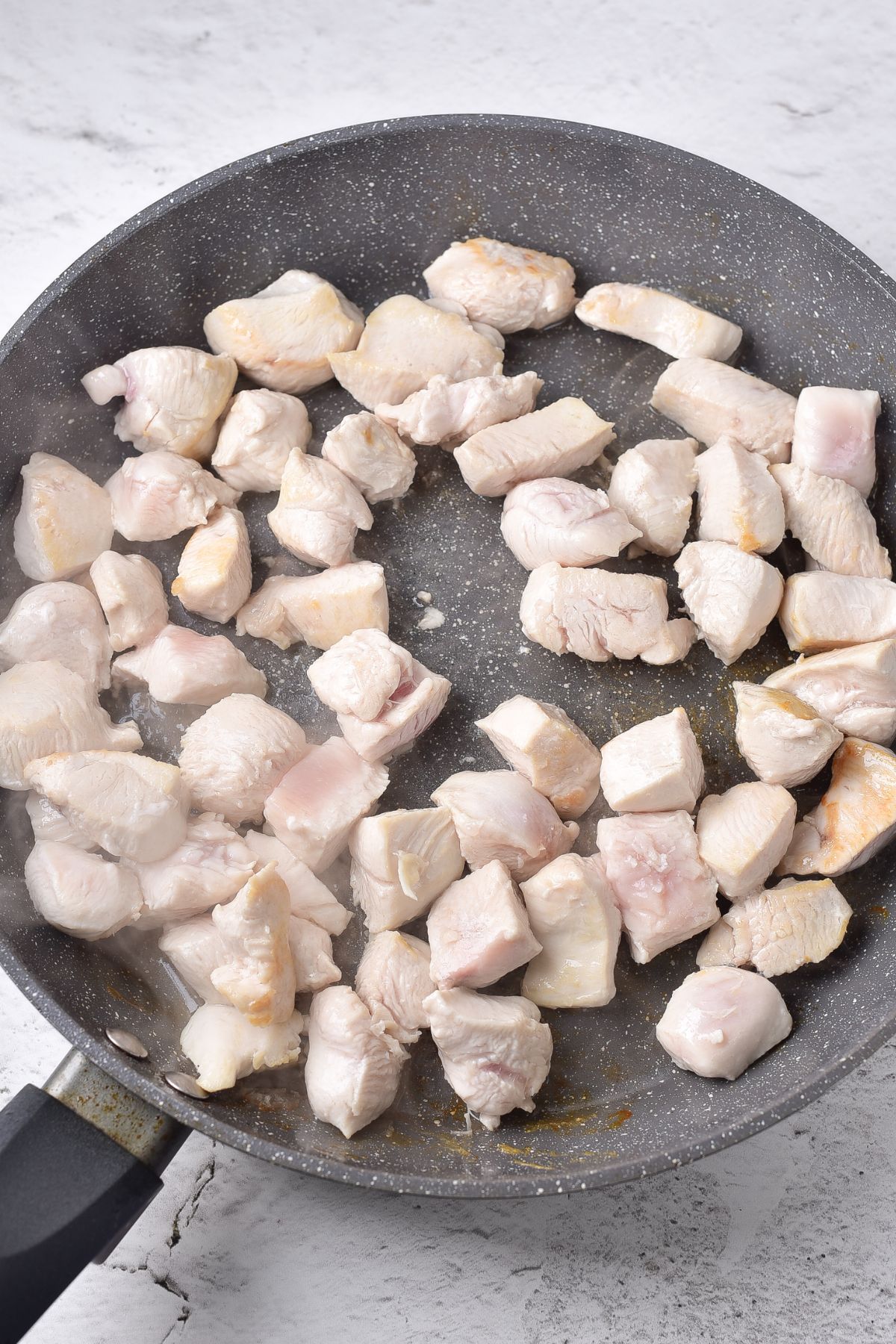 Sautéing chicken cubes in skillet.