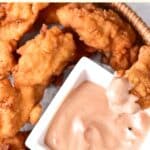 Dipping a chicken finger into sauce.