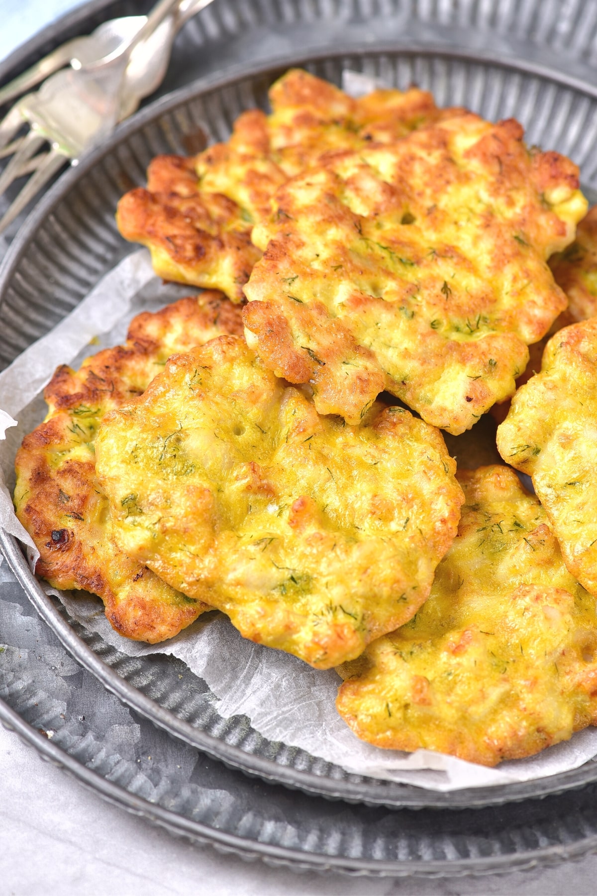 Gluten-free chicken burgers on parchment-lined plate.