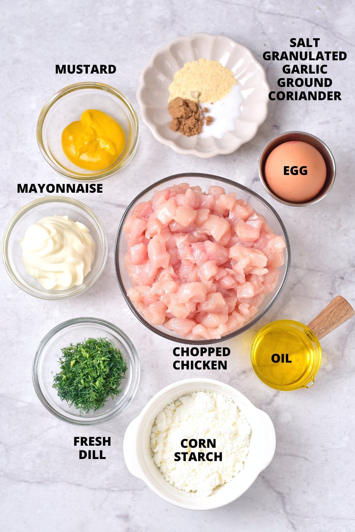 Ingredients for gluten-free chicken patties recipe on marble board.