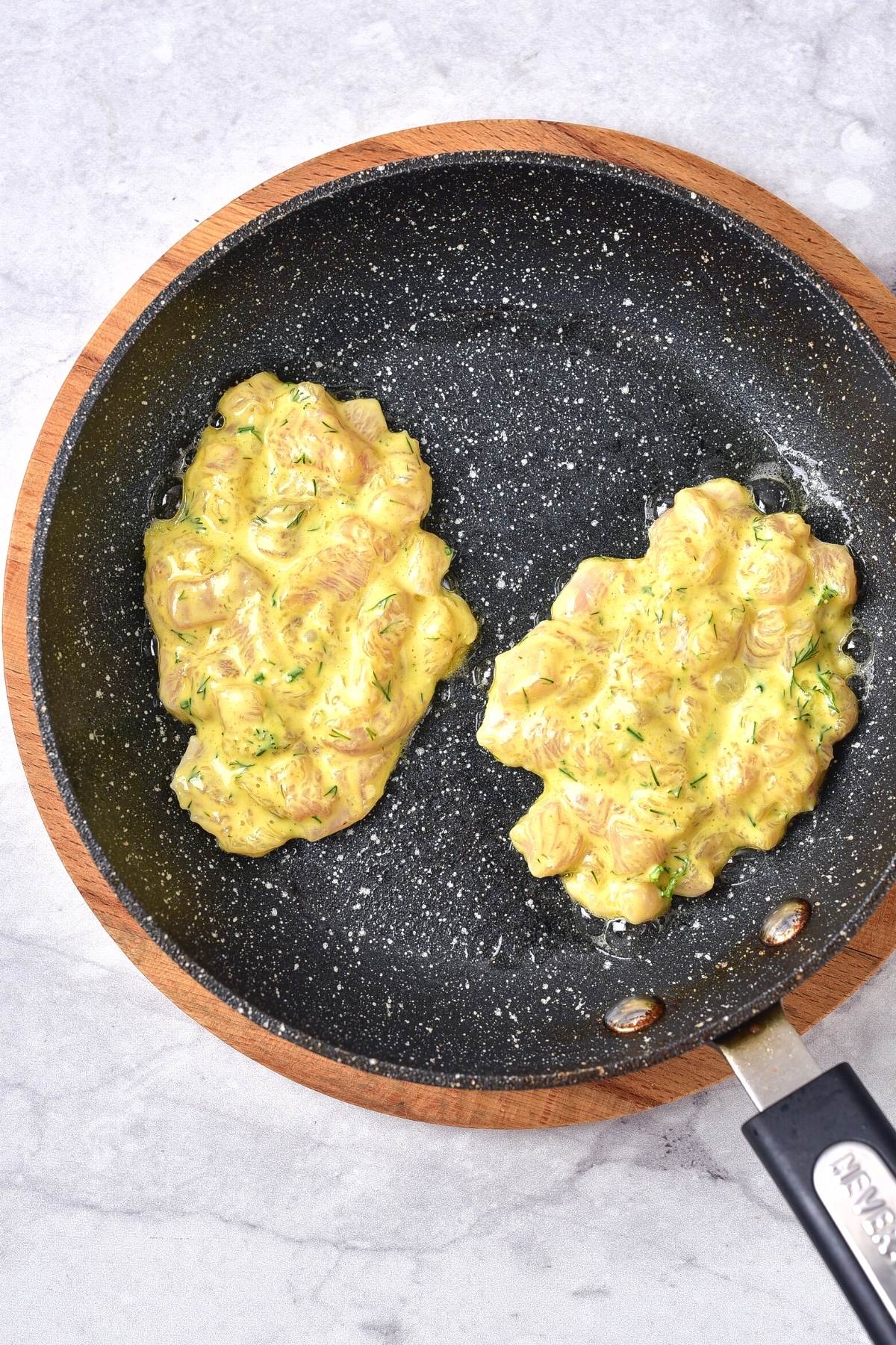 Frying chicken patties in skillet.