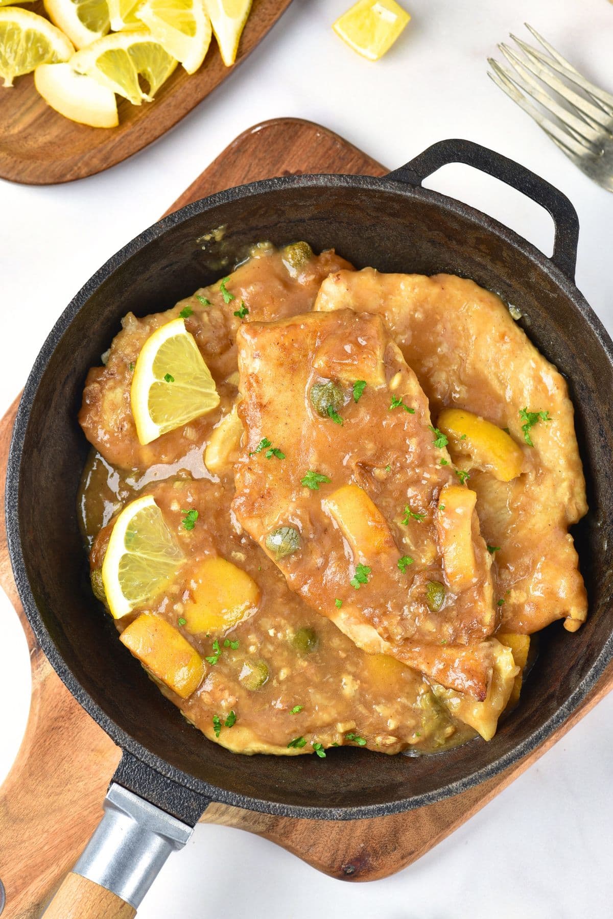 Top down view of gluten-free chicken piccata in a skillet.