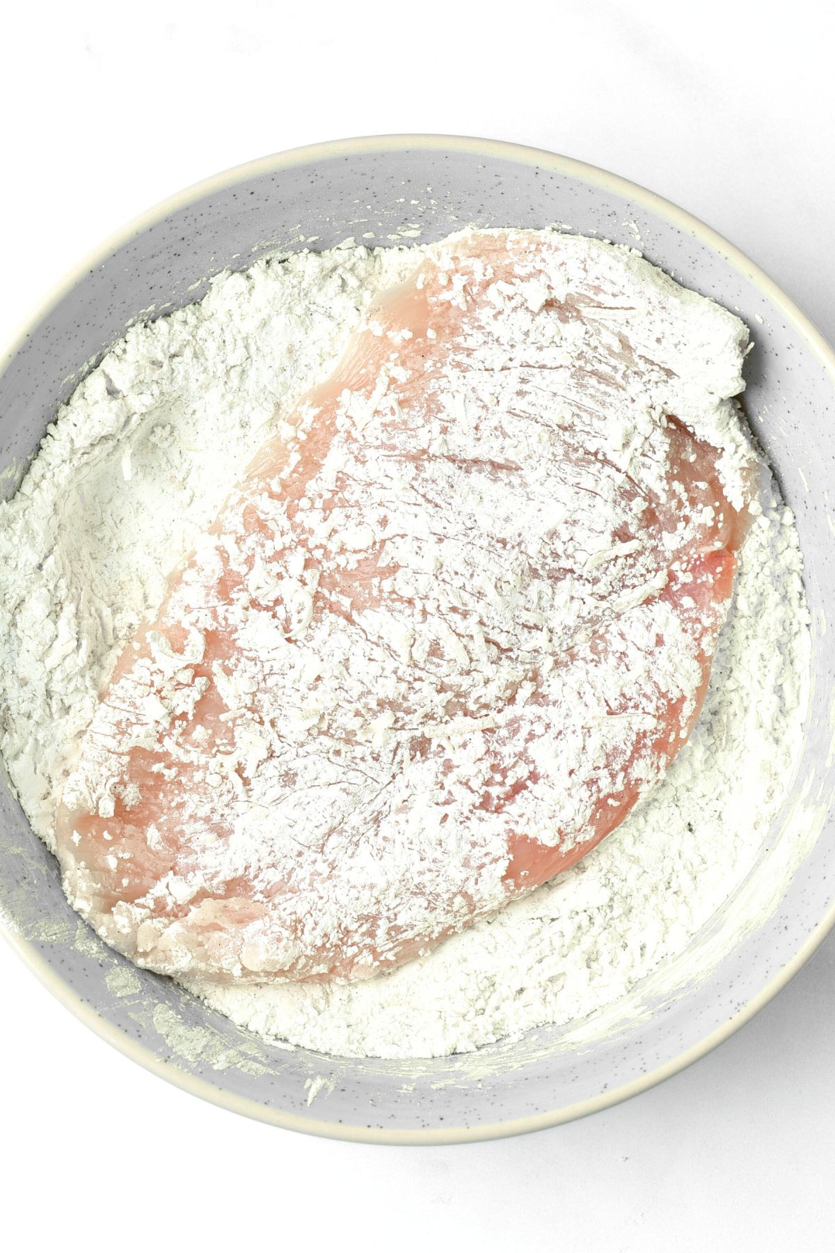 Coating chicken cutlet in flour mixture