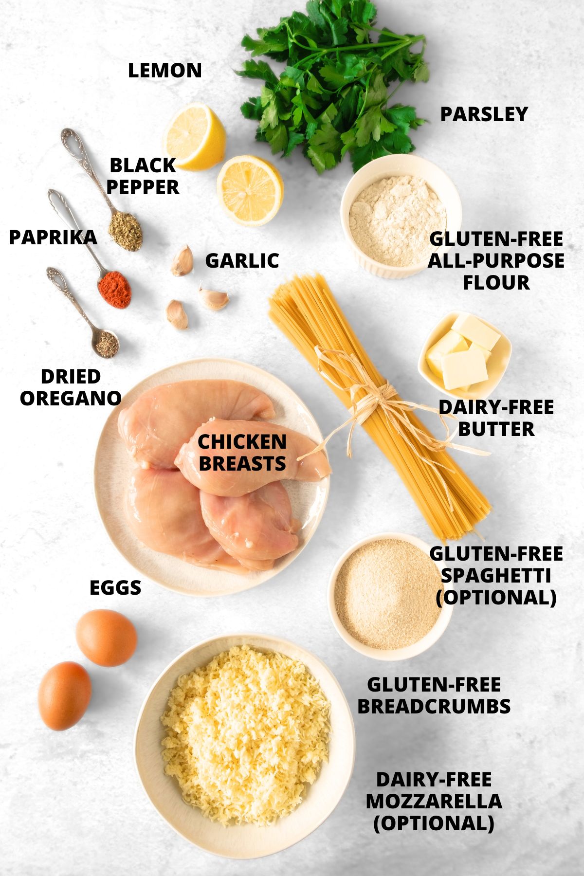 Ingredients for gluten-free chicken schnitzel recipe laid out on marble board.
