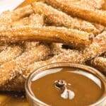Up close view of gluten-free churros and melted chocolate.