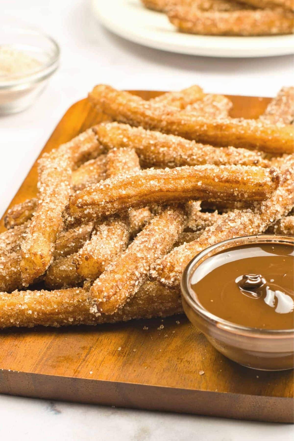 A bowl of chocolate sauce and homemade churros.